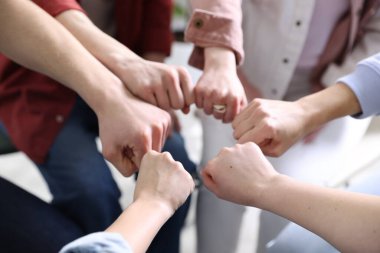 Birlik konsepti. İnsanlar kapalı mekanda yumruklarını bir arada tutarlar, yakınlaşırlar.