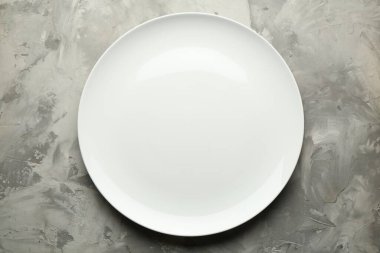 Gri desenli masa üzerindeki şık tabak, üst görünüm