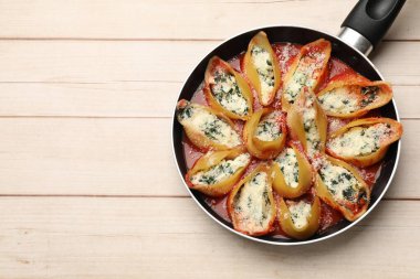 Beyaz ahşap masada ıspanak ve ricotta ile doldurulmuş lezzetli kabuklu makarna. Metin için boşluk