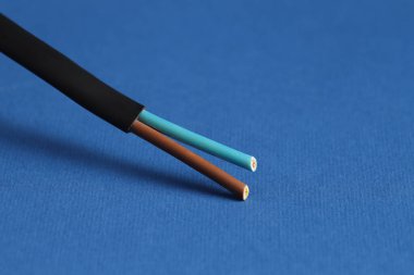 Mavi arkaplanda siyah şeritli elektrik kablosu, yakın plan.