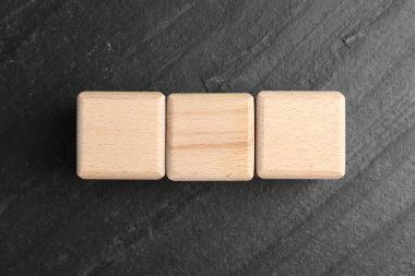 Koyu dokulu masa üzerinde boş tahta küpler, düz yatıyordu.