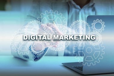 Dijital pazarlama. Bilgisayarı ve sanal ekranı kullanan işadamı masadaki dişli dişlileri kullanıyor, yakın plan