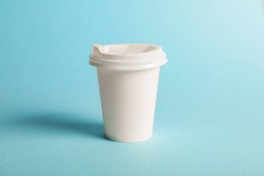 Açık mavi arka planda bir kağıt bardak. Tasarım için model