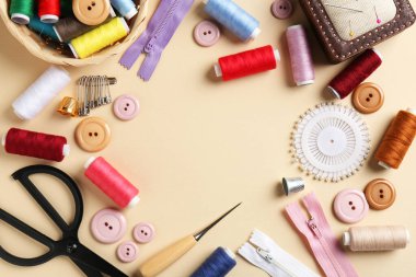 Bej arka planda farklı dikiş malzemelerinin çerçevesi düz. Metin için boşluk