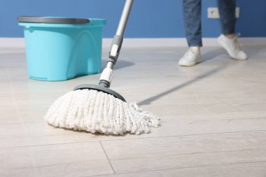 Yerleri sicim paspasla temizleyen kadın, yakın plan.