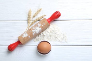 Yuvarlanan iğne, un, çiviler ve yumurta beyaz ahşap masada, düz yerde. Metin için boşluk