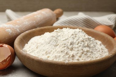 Açık gri arkaplanda yuvarlanan iğne, un ve yumurta, yakın plan.