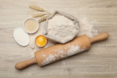 Yuvarlanan iğne ve farklı malzemeler açık ahşap masada, düz yerde.