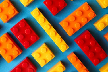 İnşaat oyuncağı. Açık mavi arkaplanda birçok renkli yapı taşı, düz yatıyordu