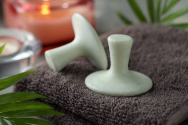 Spa taşları, havlu ve yeşil yaprak masada, yakın plan.