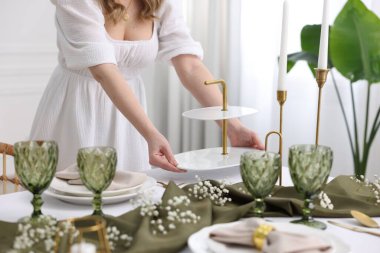 Akşam yemeği için masa hazırlayan genç bir kadın, yakın plan.