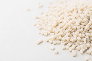 Beyaz arka planda plastik granül yığını, yakın plan. Metin için boşluk