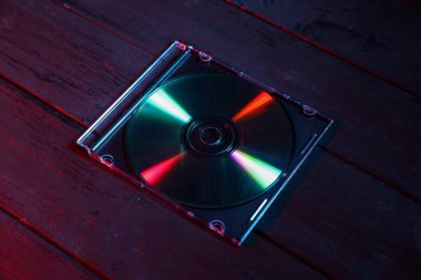 Ahşap arka planda mücevher kutusunda küçük bir disk, yakın plan.