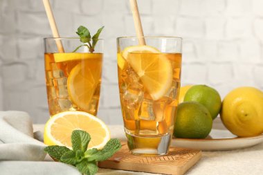 Buzlu çayı pipet, nane, limon ve limon ile tazeleyerek gri arka planda, yakın plan