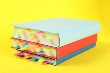 Sarı arkaplan üzerine renkli sekmeleri olan kitaplar, yakın plan