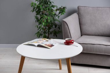 Bir bardak içki ve dergi kapalı alandaki şık kahve masasında.