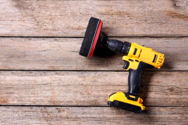 Tahta masanın üstünde cila pedi olan elektrikli tornavida. Metin için boşluk
