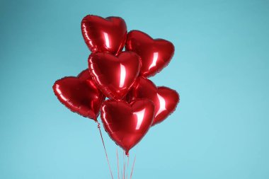 Açık mavi arka planda bir sürü kırmızı kalp şeklinde balon. Sevgililer Günün kutlu olsun.