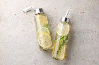 Limonlu limonlu ve biberiyeli limon suyu gri masada, üst tarafta.