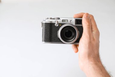 Beyaz arka planda klasik kamerası olan bir fotoğrafçı, yakın plan. Metin için boşluk