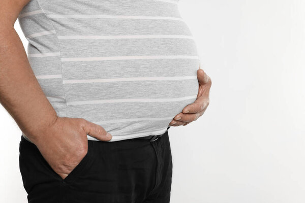 Overweight man in tight t-shirt on white background, closeup. Space for text