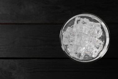 Siyah ahşap masanın üstünde buzlu buzlu soda serinletici. Metin için boşluk