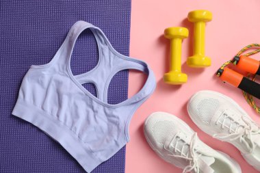 Pembe arka planda farklı spor malzemeleri, düz yatış.