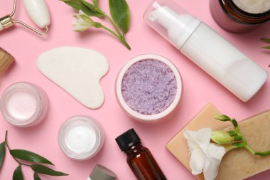 Pembe arka planda farklı vücut bakım ürünleriyle düz konum