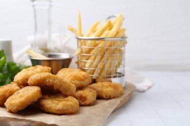 Lezzetli tavuk nugget, patates kızartması ve soslu beyaz fayanslı masa, yakın plan. Metin için boşluk
