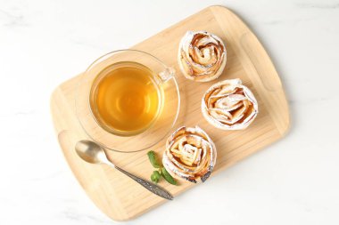 Nane şekerli taze elmalı güller ve beyaz mermer masada çay, üst manzara.