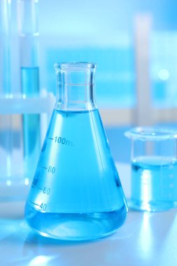 İçerideki masada sıvı bulunan laboratuvar camları.