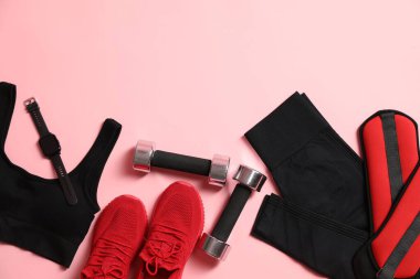 Farklı jimnastik malzemeleri ve pembe arka planda kol saati, düz yatış. Metin için boşluk
