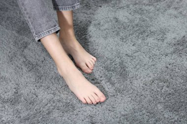 İçerideki yumuşak gri halıdaki kız, yakın plan. Metin için boşluk