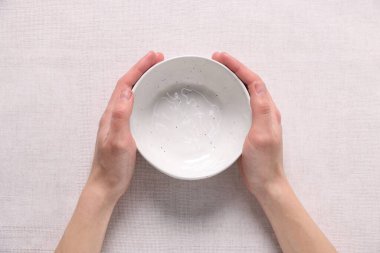 Masada boş bir kase tutan kadın, üst manzara.