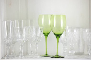 Beyaz rafta farklı boş bardaklar