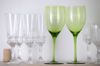 Beyaz duvarın yanındaki rafta boş temiz bardaklar var.