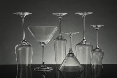 Gri arkaplana karşı ayna yüzeyinde birçok boş bardak