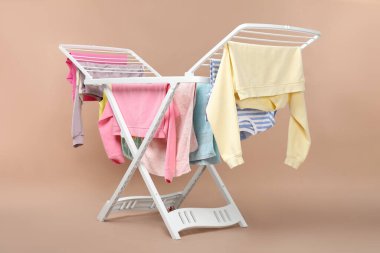 Bej arka planda temiz çamaşırlı kuru askı.