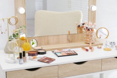 Makyaj odası. Aynalı giyinme masası, farklı güzellik ürünleri ve içeride takılar.