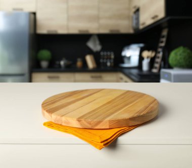 Mutfaktaki beyaz masada turuncu masa örtüsü ve yemek, yakın plan.