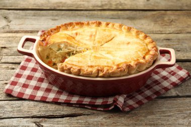 Tavuklu ve sebzeli lezzetli ev yapımı turta ahşap masada, yakın plan.