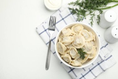 Lezzetli hamur tatlısı ve bembeyaz masada servis edilen dereotlu kase. Metin için boşluk