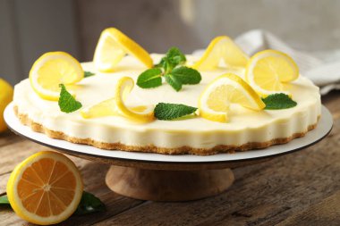 Nefis limonlu cheesecake, nane ve taze meyveli ahşap masa, yakın plan.