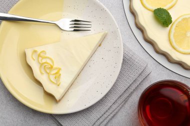 Lezzetli limonlu cheesecake ve çay gri desenli masa, düz uzanma