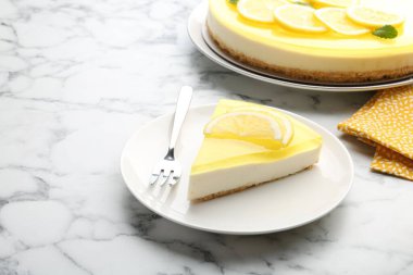 Lezzetli limonlu cheesecake ve çatal beyaz mermer masa, yakın plan. Metin için boşluk