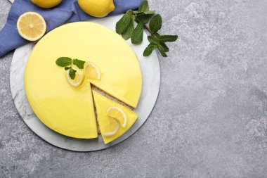 Lezzetli limonlu cheesecake, nane ve narenciye meyveleri gri desenli masa, düz yatak. Metin için boşluk