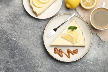 Gri desenli masada servis edilen leziz limonlu cheesecake parçaları. Metin için boşluk