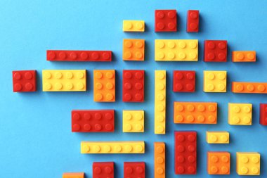 İnşaat oyuncağı. Açık mavi arkaplanda birçok renkli yapı taşı, düz yatıyordu