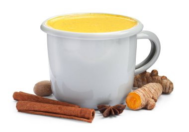 Beyaz bardakta lezzetli zerdeçal latte ve baharatlar.