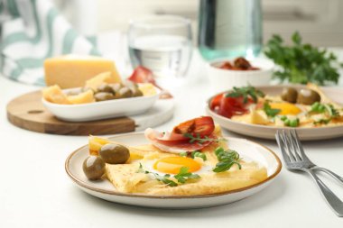 Beyaz masada servis edilen yumurta ve pastırmalı leziz krepler.